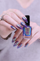 beautiful female hand with long nails, purple and blue manicure 