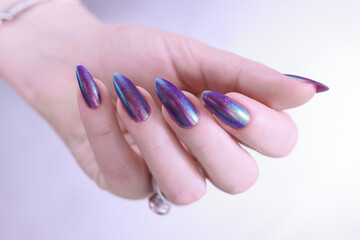 beautiful female hand with long nails, purple and blue manicure 