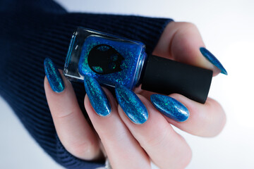 Woman's beautiful hand with long nails and bright blue manicure 