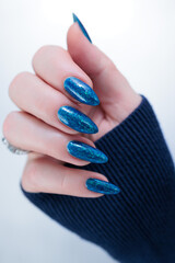 Woman's beautiful hand with long nails and blue and green manicure	