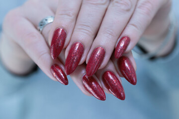 Female hands with long nails and dark black red nail polish