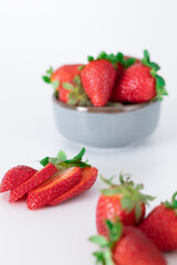 Fresh strawberries in ceramic bowl on white background