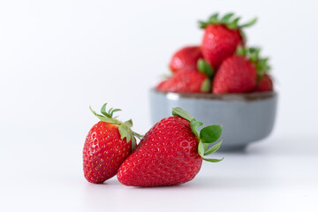 Fresh strawberries in ceramic bowl on white background