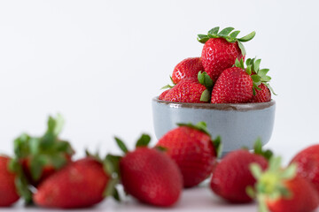 Fresh strawberries in ceramic bowl on white background