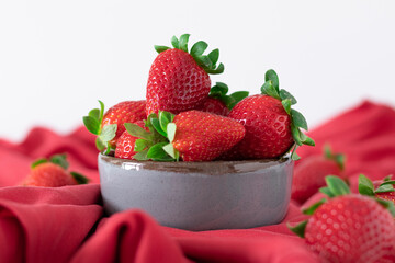 Fresh strawberries in ceramic bowl on white background