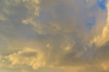 Yellow-blue gray clouds in the evening summer sky. Cumulus clouds.