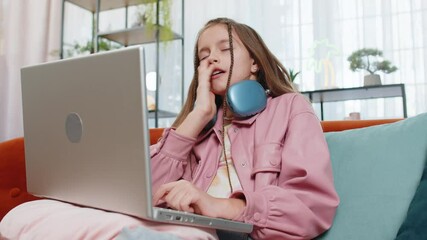 Tired young pupil girl student feeling boring with study or work at home. Stressed female teenage child exhausted from remote distance online education learning hard program on laptop computer indoors