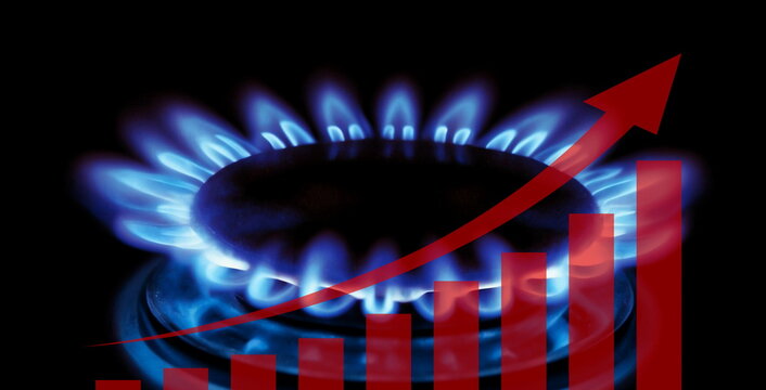 Natural Gas. High prices of natural gas. Blue flames of gas burning from a kitchen gas stove. Energy crisis concept, cost growth concept with burners and stock charts price reduction chart.
