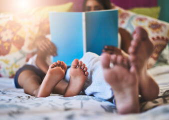 Feet, bed or mother and kid reading book in house for learning, support and bonding at home together. Love, family and child with mom in bedroom with literature, fantasy and storytelling education