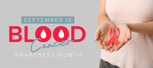 Woman with red ribbon on light background, closeup. Banner for Blood Cancer Awareness Month