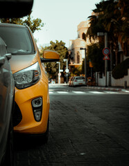 Fototapeta premium Closeup headlight of modern sport yellow car. Over city background.