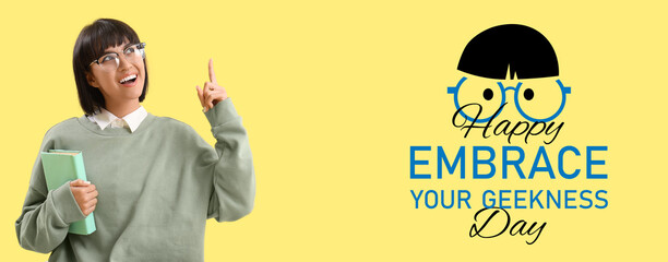 Young woman with book pointing at something on yellow background