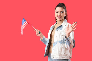 Young woman with USA flag waving hand on red background