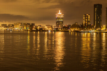 Naklejka premium Der Hafen in Amsterdam bei Nacht, mit dem A’DAM Lookout und der spektakulären Schaukel über dem Gebäuderand