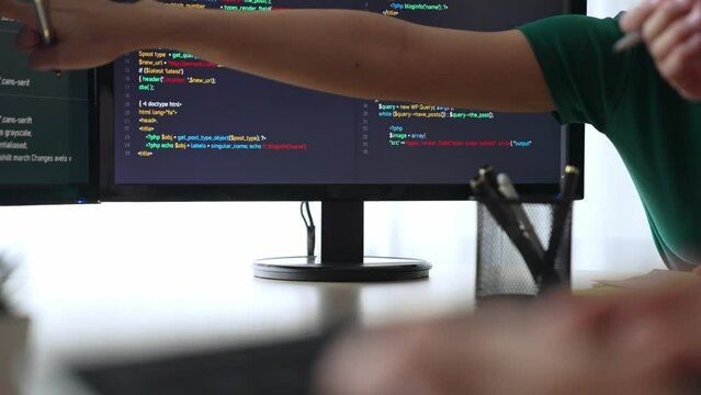 Slow motion back end software developer engineer for computer programming working together on debugging writing computing code, solving complex algorithms display on monitor in office. Burgeoning