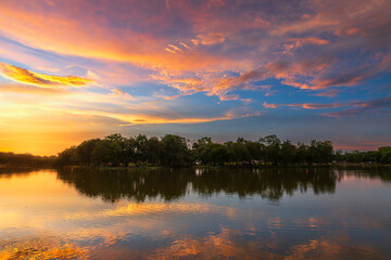 Fototapeta premium landscape lake views and the reservoir the forest summer water reflection with Twilight blue bright and orange yellow dramatic sunset sky in beach colorful nature background.