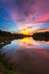 landscape lake views and the reservoir the forest summer water reflection with Twilight blue bright and orange yellow dramatic sunset sky in beach colorful nature background.
