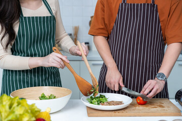 close up hand loving young asian of having fun standing a cheerful preparing food and enjoy cook steak cooking and vegetables, meat, bread while standing on a kitchen Condo life or home