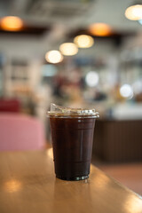 Close-up of Americano ice coffee or black coffee in cup mug on  wood desk office desk in coffee shop at the cafe in garden,during business work concept