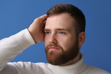Obraz premium Handsome bearded man on blue background, closeup