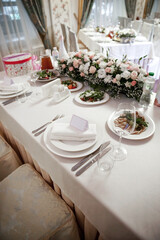 Empty glasses and dishes on a wedding table with flowers