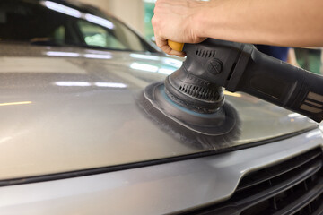 Car detailing enhances shine of vehicle with machine buffer for glossy finish