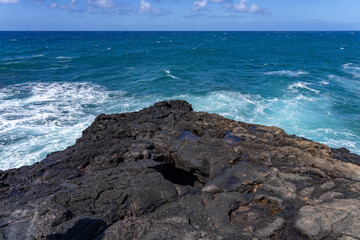 Waves hitting the Lava rock， Makahuena Light, Koloa, Kauai South Shore，Hawaii. Koloa Volcanics	，basalt