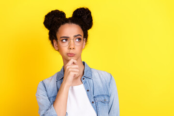 Portrait of nice young girl look empty space wear denim shirt isolated on yellow color background