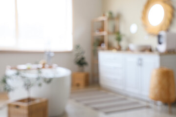 Interior of stylish bathroom with bathtub, sink and cosmetic refrigerator, blurred view