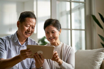senior asian couple using digital tablet together at home
