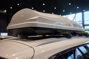 White vehicle with roof box, hood, grille, bumper and automotive lighting