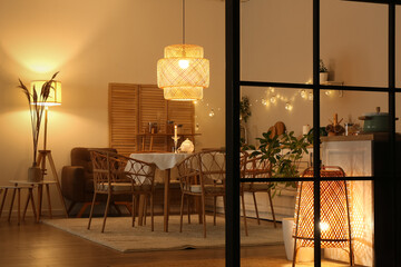 Interior of modern kitchen with glowing lamps at evening