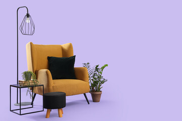 Beautiful brown armchair with houseplant, coffee table and lamp on lilac background