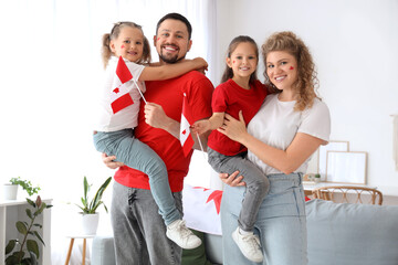 Happy family with flags of Canada at home