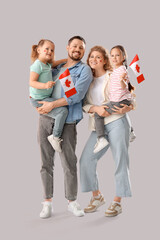 Fototapeta premium Happy beautiful family with flags of Canada on grey background