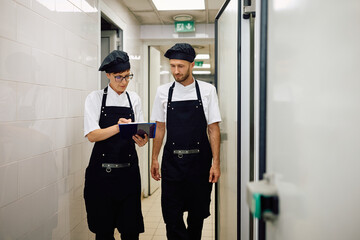 Two chefs analyzing menu while working in restaurant.