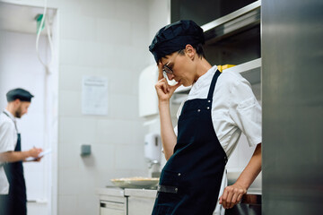 Distraught female chef in  kitchen at restaurant.