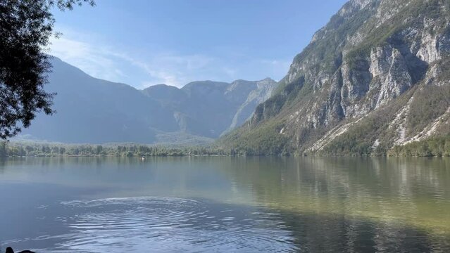 A beautiful lake with mountains in the background. The water is calm and clear, reflecting the mountains in the distance