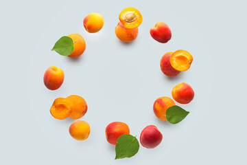 Frame made of flying apricots with leaves on grey background