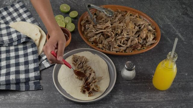 	Preparing an Arabic taco with spicy red chipotle sauce