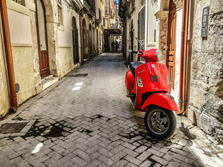 red motorcycle scooter on an old italy street