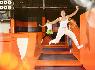 Happy young girl doing jumping at the trampoline center