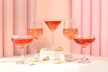 Modern summer still life with pink martini, alcoholic cocktail Aperol spritz, champagne and seashells on elegant modern background, minimal concept for bar and holiday party, cafe, advertising banner