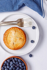 Mini blueberry pie on the plate, overhead view