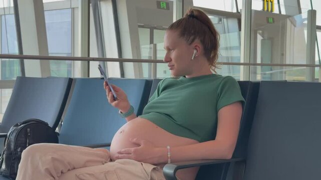 happy pregnant woman traveling alone, waiting for plane at airport, second or third trimester 