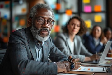 Obraz premium Mature Businessman in Meeting With Colleagues at Workplace
