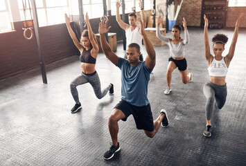 Class, fitness and lunge in group at gym for workout, core exercise or training together indoors. Diverse people, friends or warm up for ab muscle, session and sport for health challenge in gymnasium