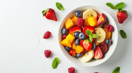 Fresh fruit salad in a white bowl on a white background. A healthy meal for the summer.
