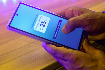 Man checking approximate emergency department Wait Times or restaurant wait times on his phone. Real-time prediction using machine learning concept.