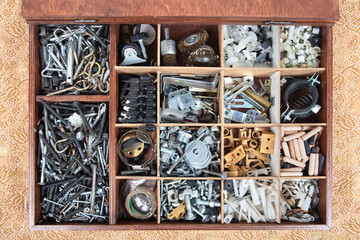 Organized Toolbox with Various Hardware Components. A top-down view of a meticulously organized toolbox filled with an assortment of hardware components, including screws and other small parts. 